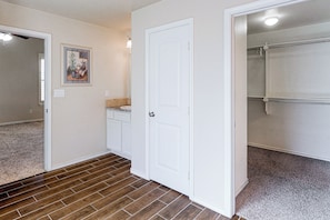 A hallway with a white door, a bathroom with a shower, and a carpeted floor. - Grill & Yard! Family Escape, 8 Mi to Dtwn Odessa (Odessa)