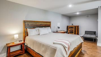 A neatly arranged bedroom with a wooden bed, bedside tables, a desk, and a chair.