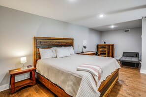 A neatly arranged bedroom with a wooden bed, bedside tables, a desk, and a chair.