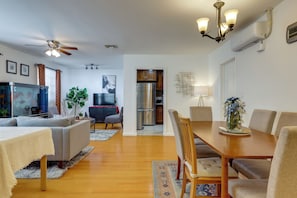 A spacious living room with a sofa, TV, and a dining area with a table and chairs.
