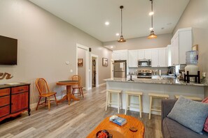 A modern kitchen with white cabinets, a built-in microwave, and a stainless steel refrigerator.