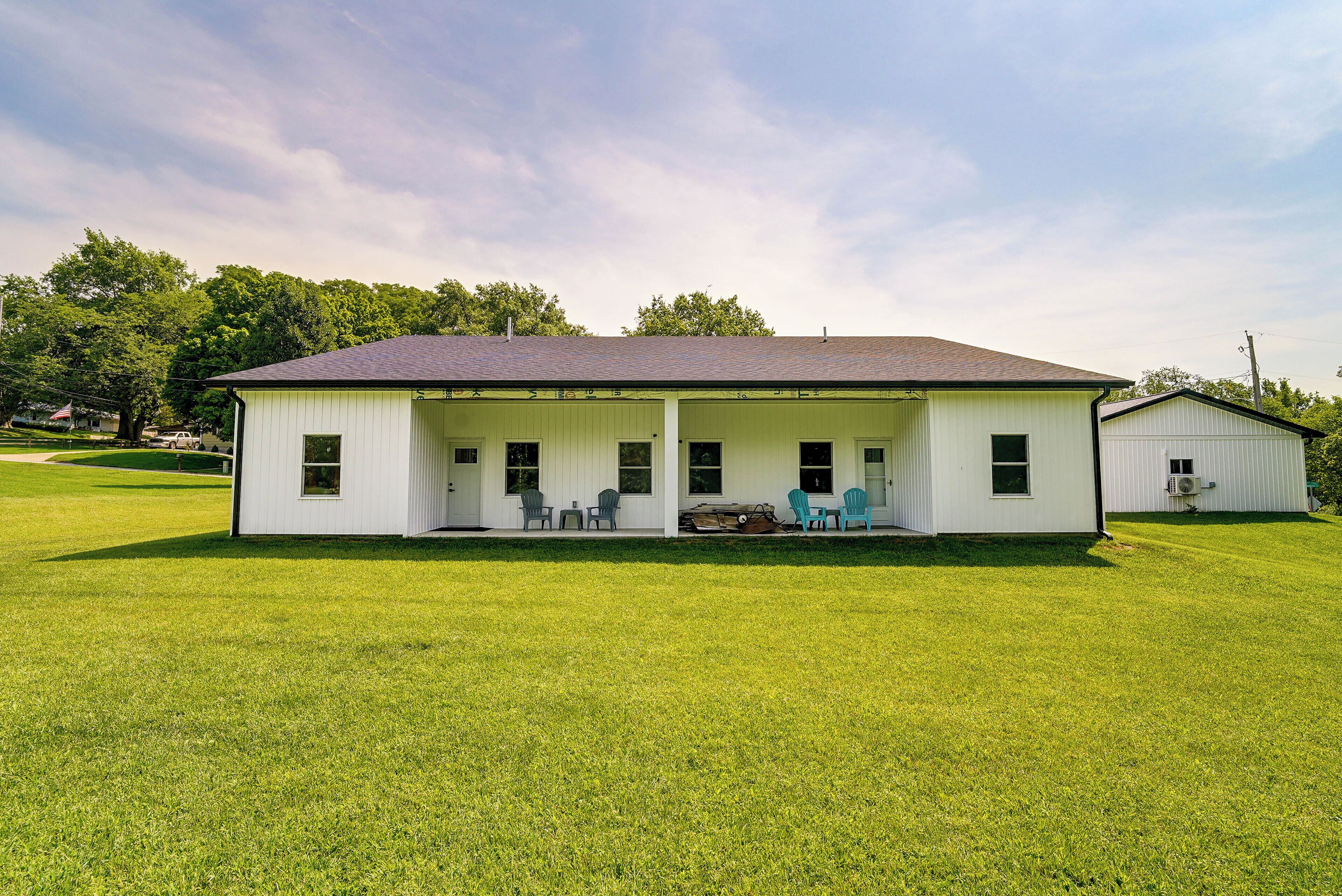 A single-story house with a porch, a small shed, and a well-maintained lawn.