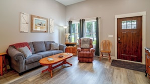 A living room with a sofa, a chair, a coffee table, and a door. - Near Parks & Dtwn Clarinda! 'house of Stroburg' (Clarinda)