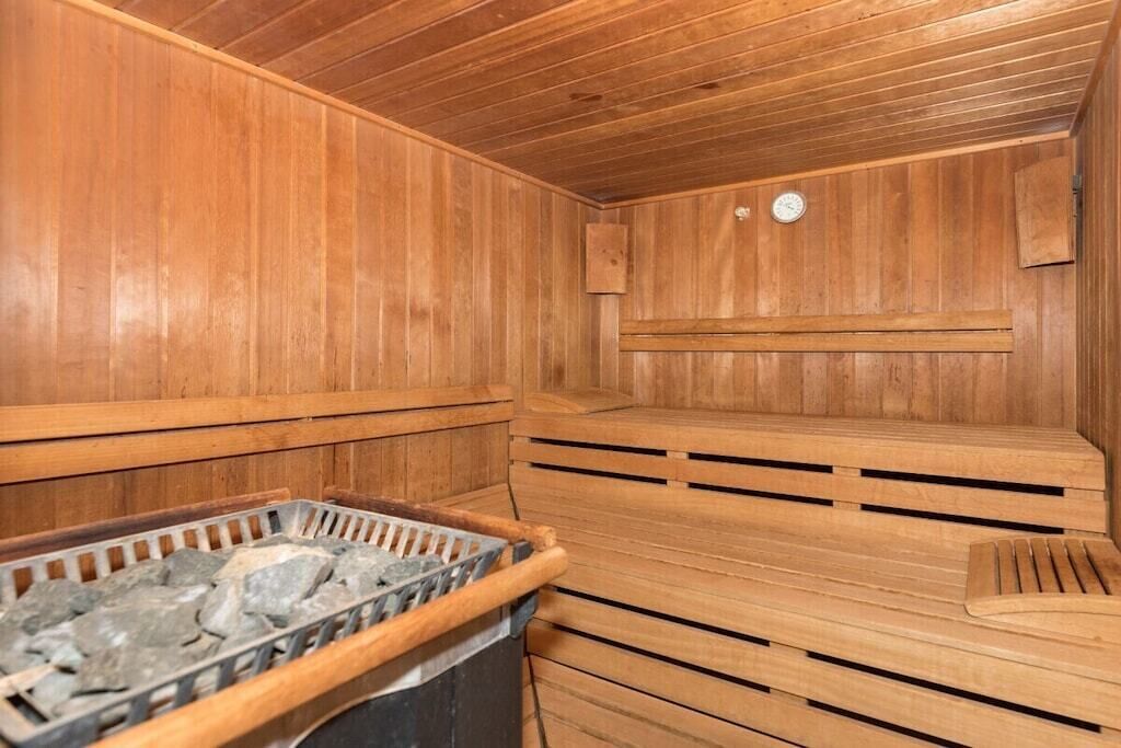Una sauna in legno con panche e un elemento riscaldante in pietra.