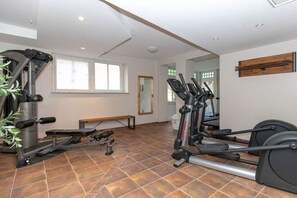 A gym with cardio machines, a bench, and a mirror. - Holiday apartment Dünenschloss 319668 (Kühlungsborn)