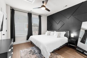 A modern bedroom with a bed, bedside table, and a ceiling fan. - South End - Central Charlotte Retreat (Charlotte)