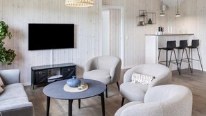 A modern living room with a flat-screen TV, a round coffee table, and two armchairs. - VillaVilla 1001 - Marielyst, Lolland/Falster/møn (Idestrup)