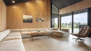 A modern living room with a sectional sofa, a coffee table, and a leather armchair.