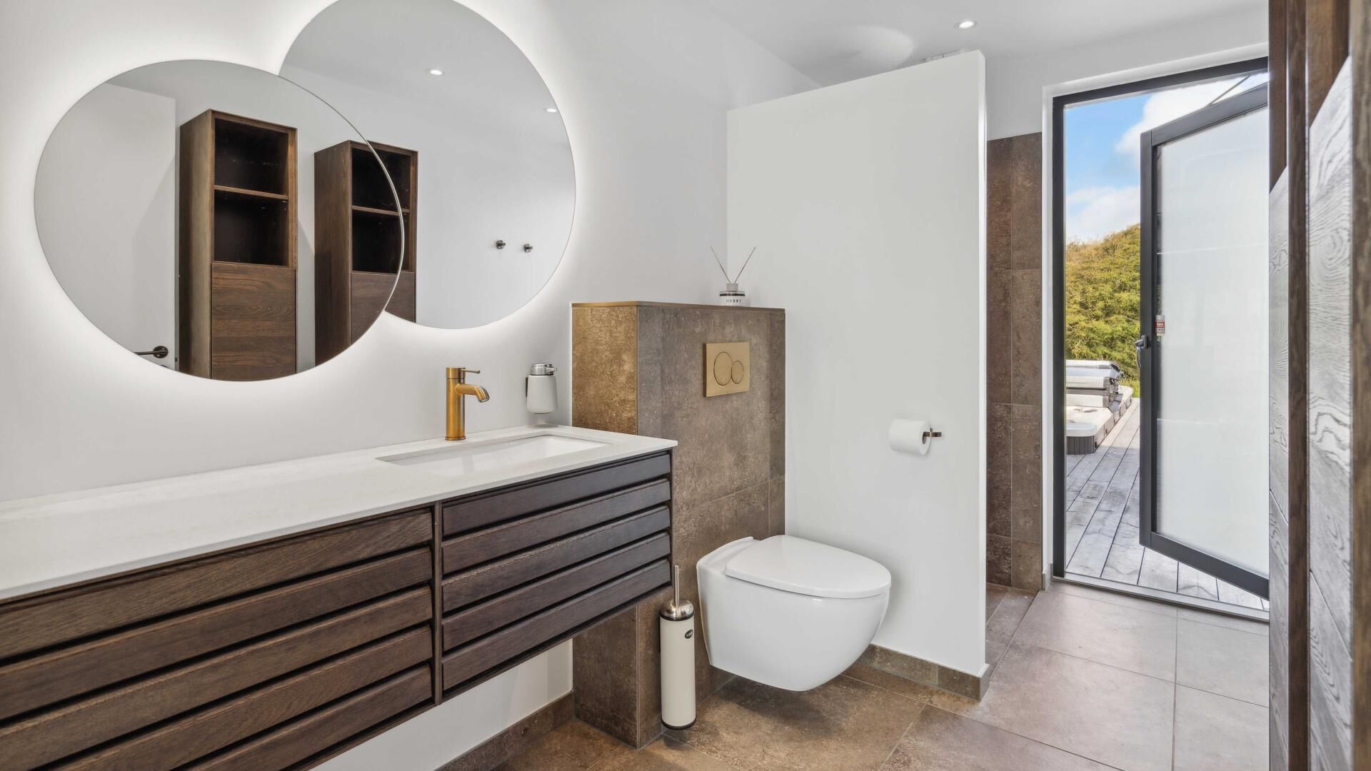 A modern bathroom with a large mirror, a sink, a toilet, and a shower area.