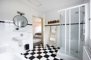 A modern bathroom with a checkered floor, a glass shower enclosure, and a wooden ladder. - Holiday home with 2 bedrooms (Appelscha)