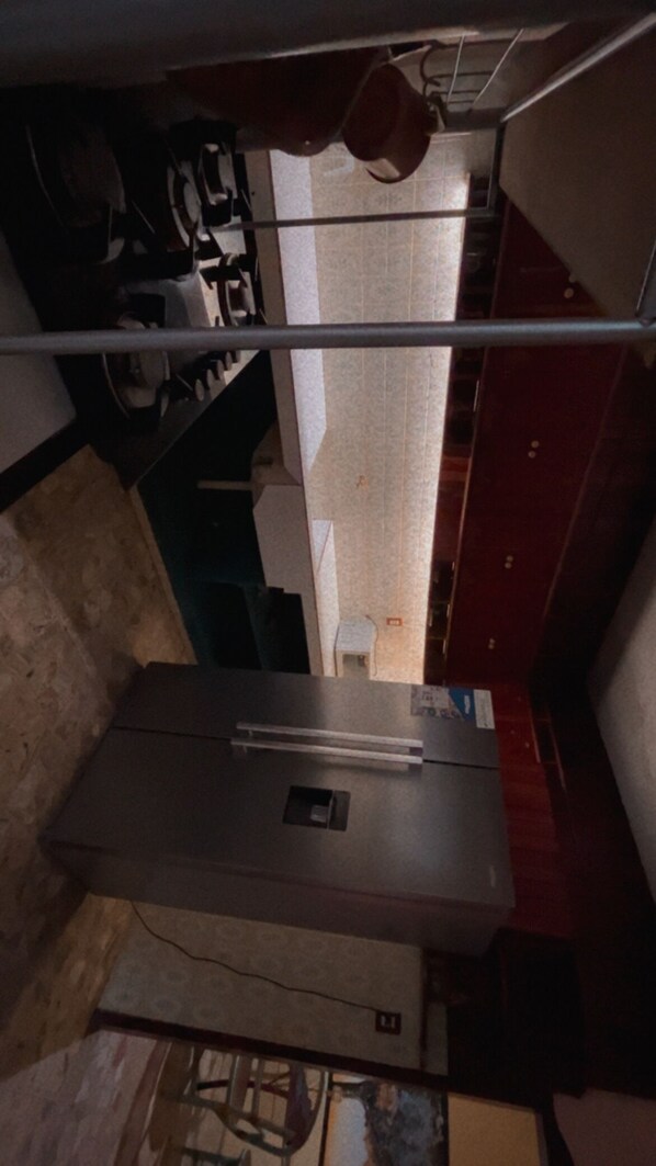 A kitchen with a stainless steel refrigerator, a gas stove, and a tiled backsplash.