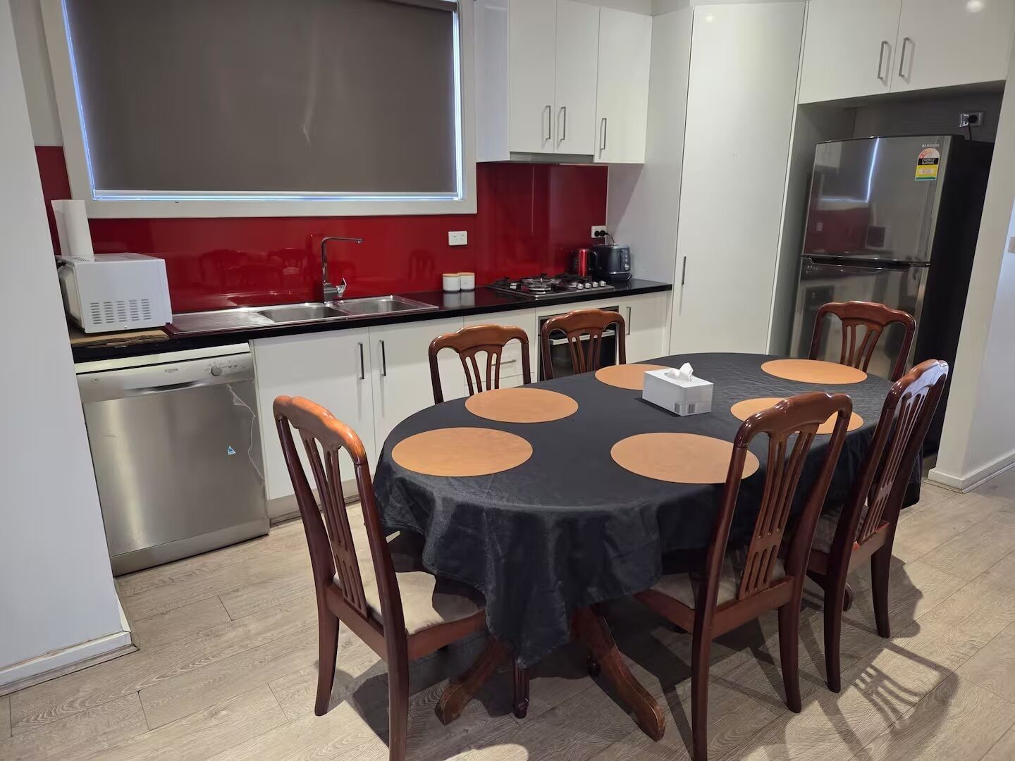 Una cocina compacta con comedor, equipada con lavavajillas, refrigerador y estufa.