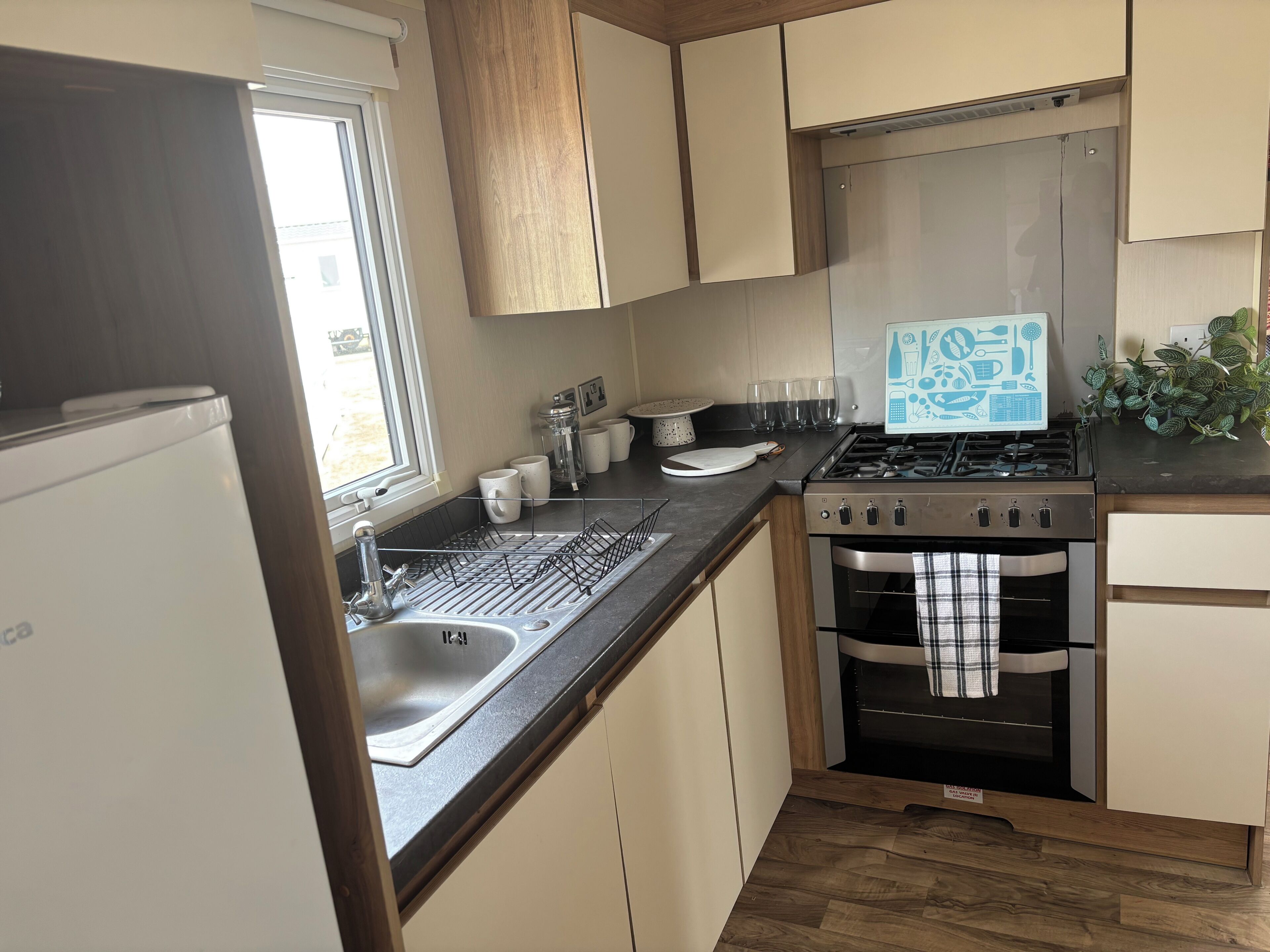 Eine kleine Küche mit integriertem Backofen, Spüle und Herd.