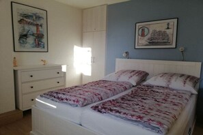 Een slaapkamer met een bed, een kaptafel en twee wandlampen.