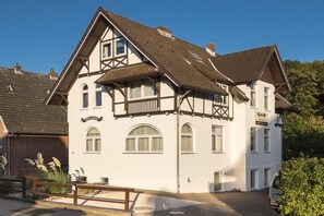 Ein traditionelles Fachwerkhäuschen mit vielen Fenstern und einem Balkon.