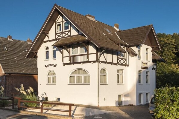 A traditional half-timbered building with multiple windows and a balcony. - Holiday apartment with 2 bedrooms (Travemünde)