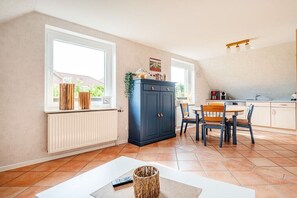 Un coin repas comprenant une table et des chaises, un buffet et un radiateur.