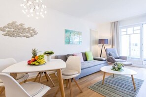 A modern living room with a dining area, a sofa set, a coffee table, and a decorative wall piece. - 621 in the Strandvilla Seeadler (Ostseebad Binz)