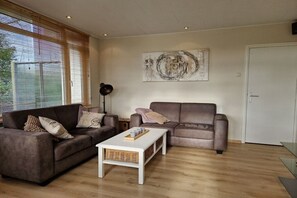 A living room with two sofas, a coffee table, and a floor lamp. - Bungalow with 2 bedrooms (Oostkapelle)