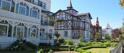 Un edificio de estilo europeo tradicional con un jardín delantero.