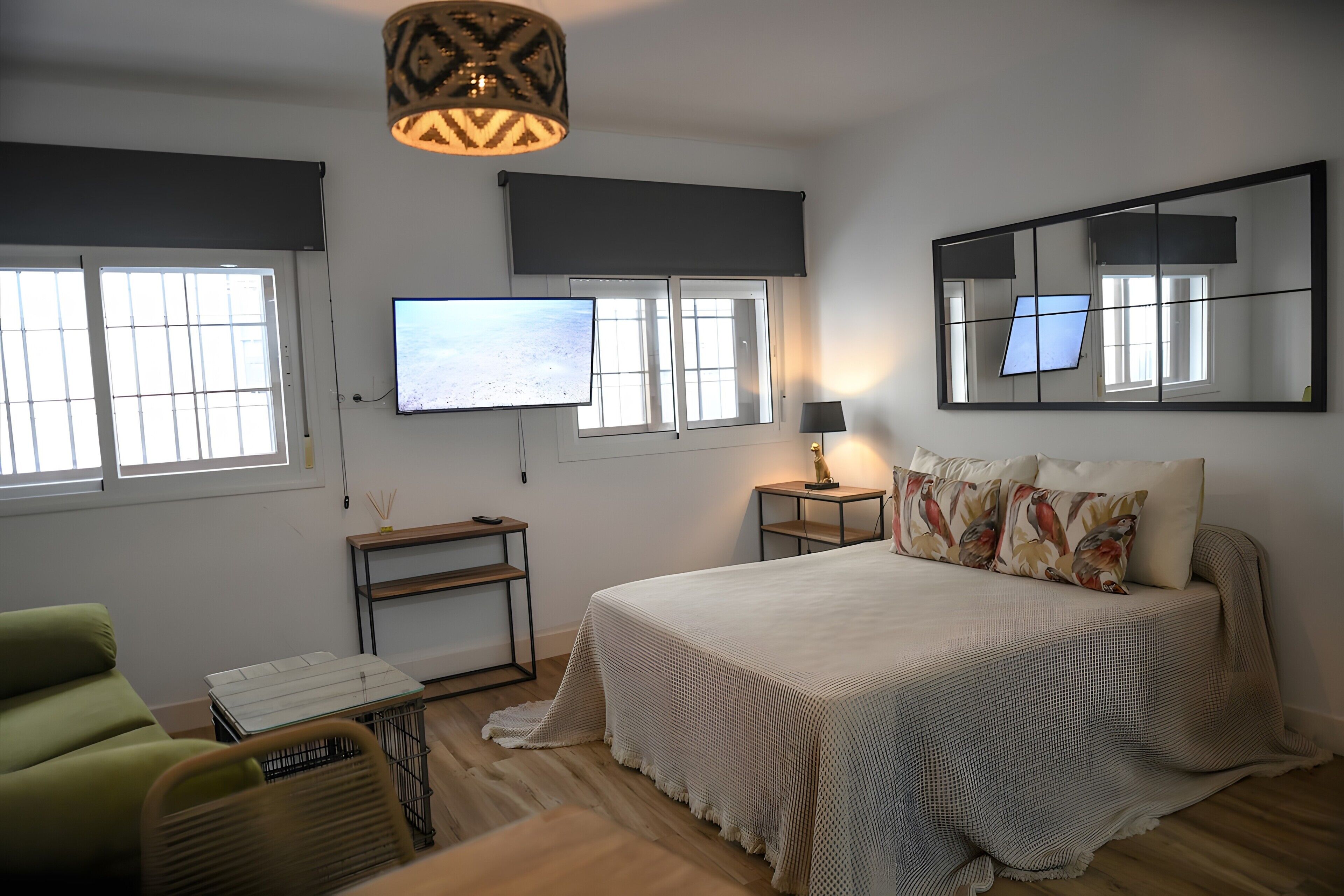 Ein Schlafzimmer mit Bett, Fernseher, Schreibtisch, Stuhl und Lampe.