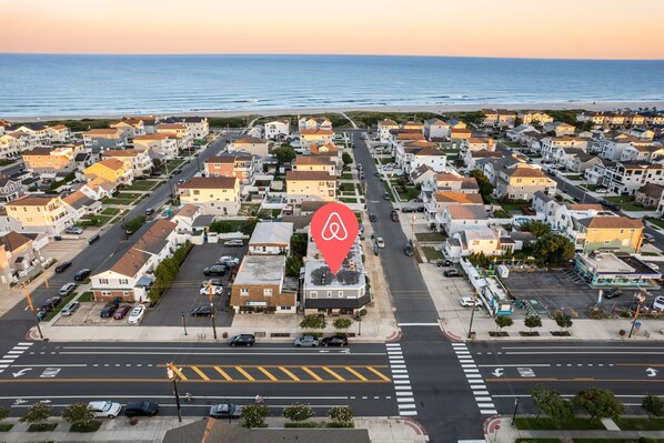 Zona residencial com casas, ruas e uma praia ao fundo.