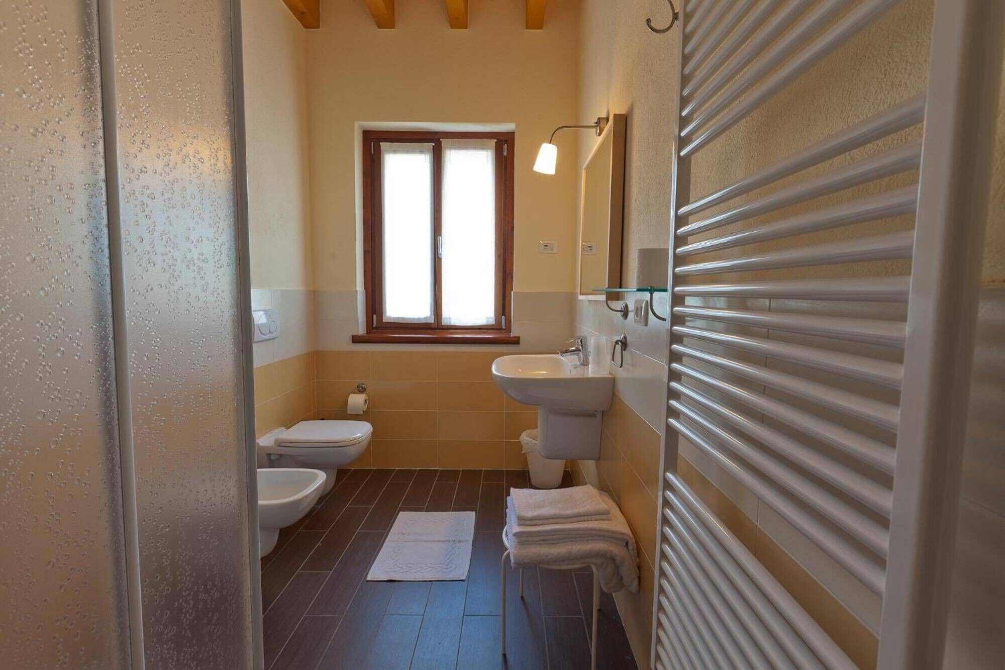 A bathroom with two toilets, a sink, and a window.