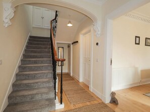 Eine Treppe mit Holzwand und Teppichstufen, die zu einer Tür führen.