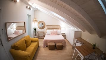 Quarto com cama, sofá, escrivaninha e cadeira.
