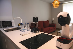 Una cocina moderna equipada con microondas, hervidor de agua y cafetera.