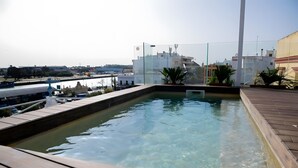 A rooftop swimming pool with clear water, surrounded by a wooden deck and potted plants. - Cozy Studio with All Amenities in One Space (El Puerto de Santa María)