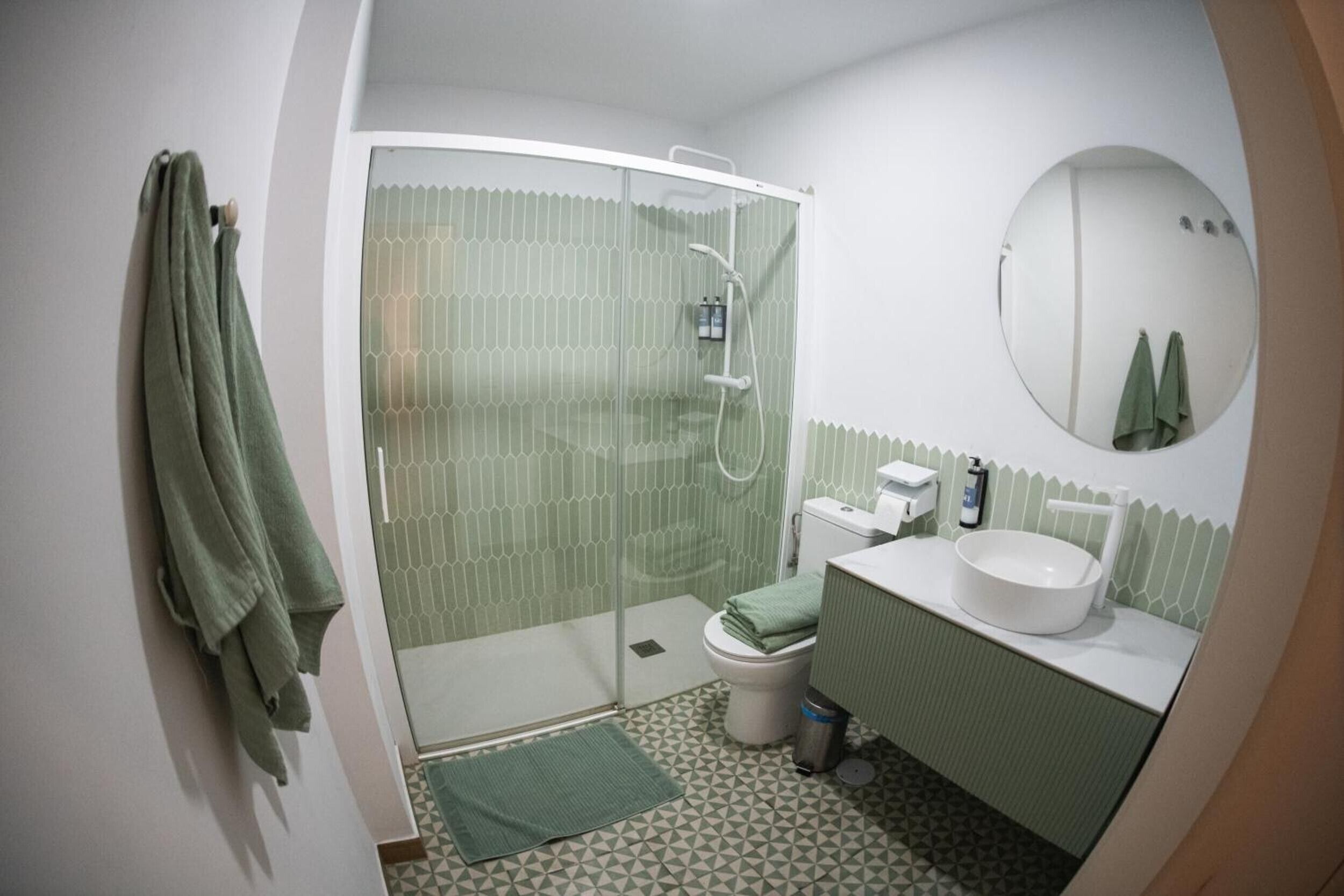Une salle de bain équipée d’une douche, de toilettes, d’un lavabo et d’un miroir.