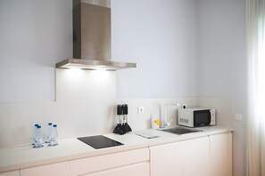 A modern kitchen with a stainless steel range hood, a microwave, and a water dispenser. - Bright, Well-Equipped Superior Apartment (El Puerto de Santa María)