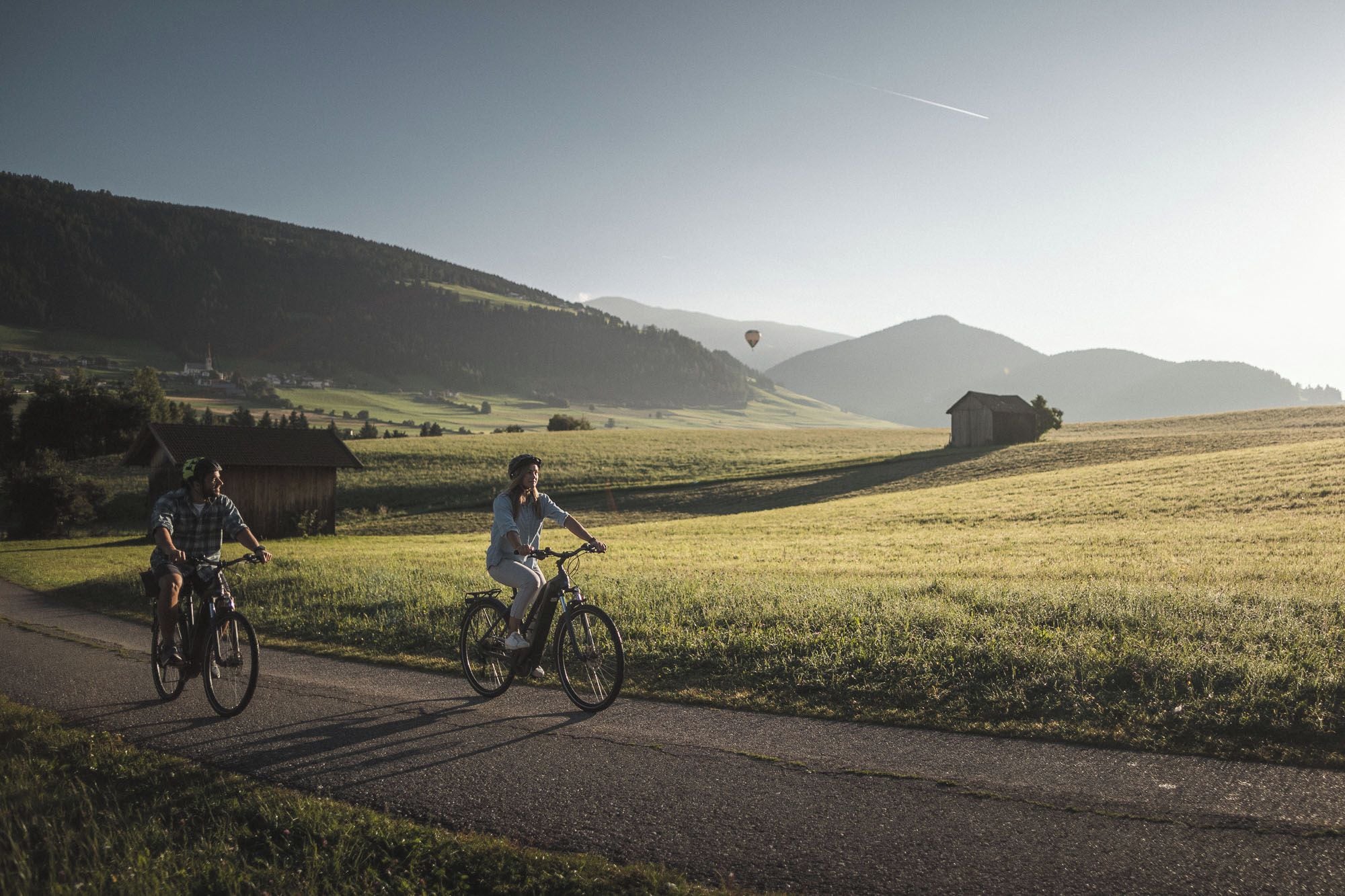 Un camino rural con ciclistas y cielo despejado.