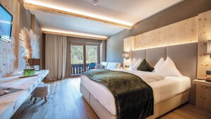 Un dormitorio moderno con una cama grande, un escritorio y vistas al exterior.
