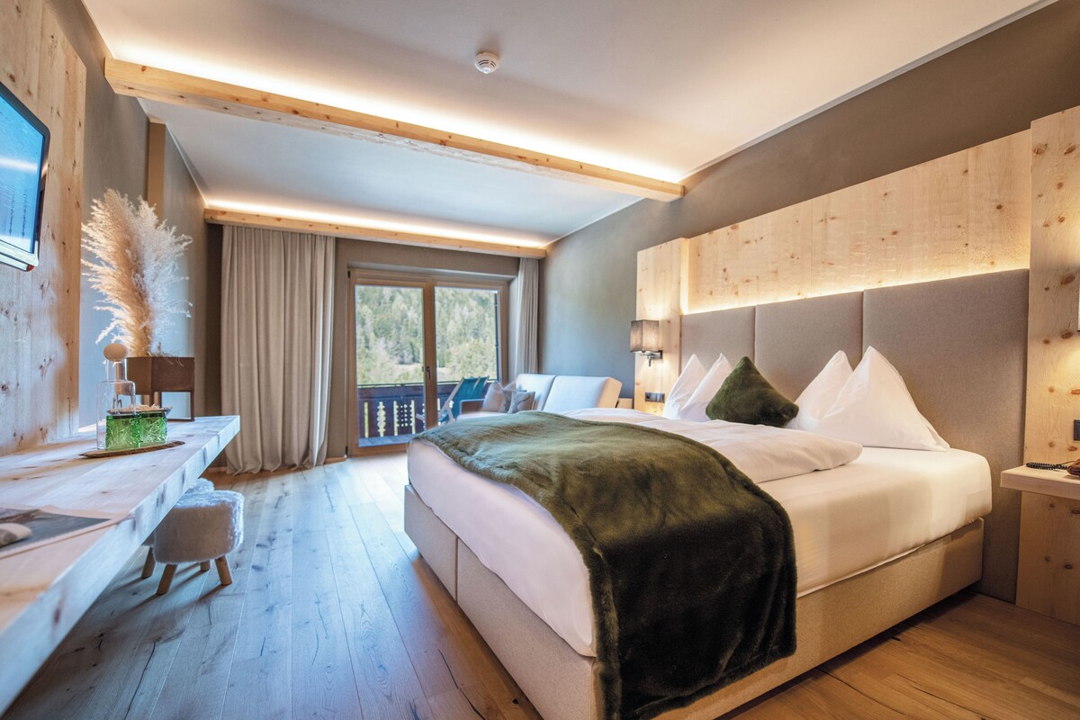 Un dormitorio moderno con una cama grande, un escritorio y vistas al exterior.