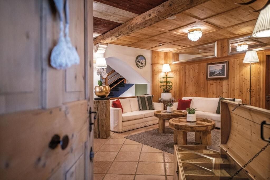 A wooden interior with a staircase, a white sofa, and a coffee table.