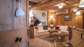 A wooden interior with a staircase, a white sofa, and a coffee table.