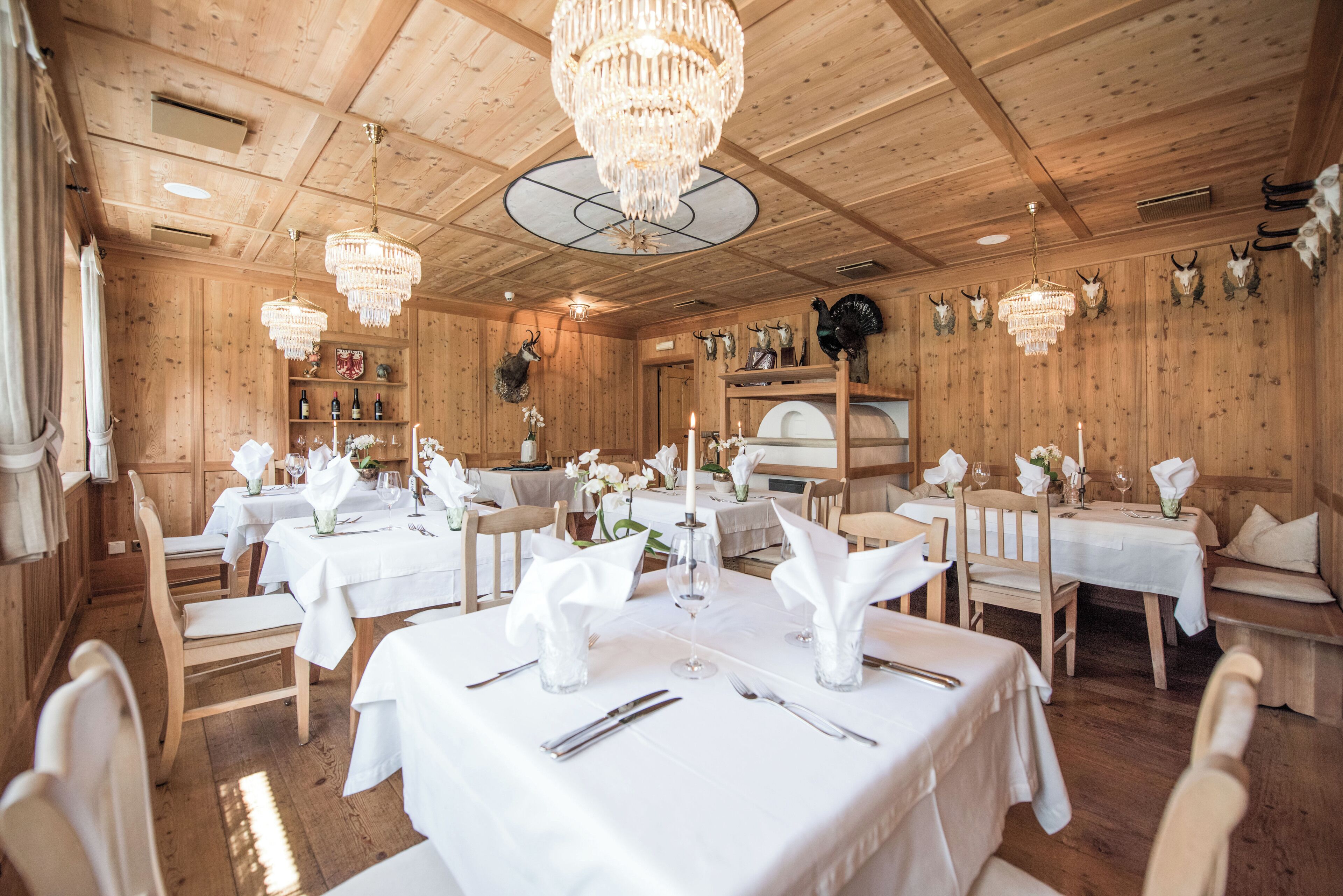 Un restaurante con interiores de madera, candelabros y mesas dispuestas para comer.