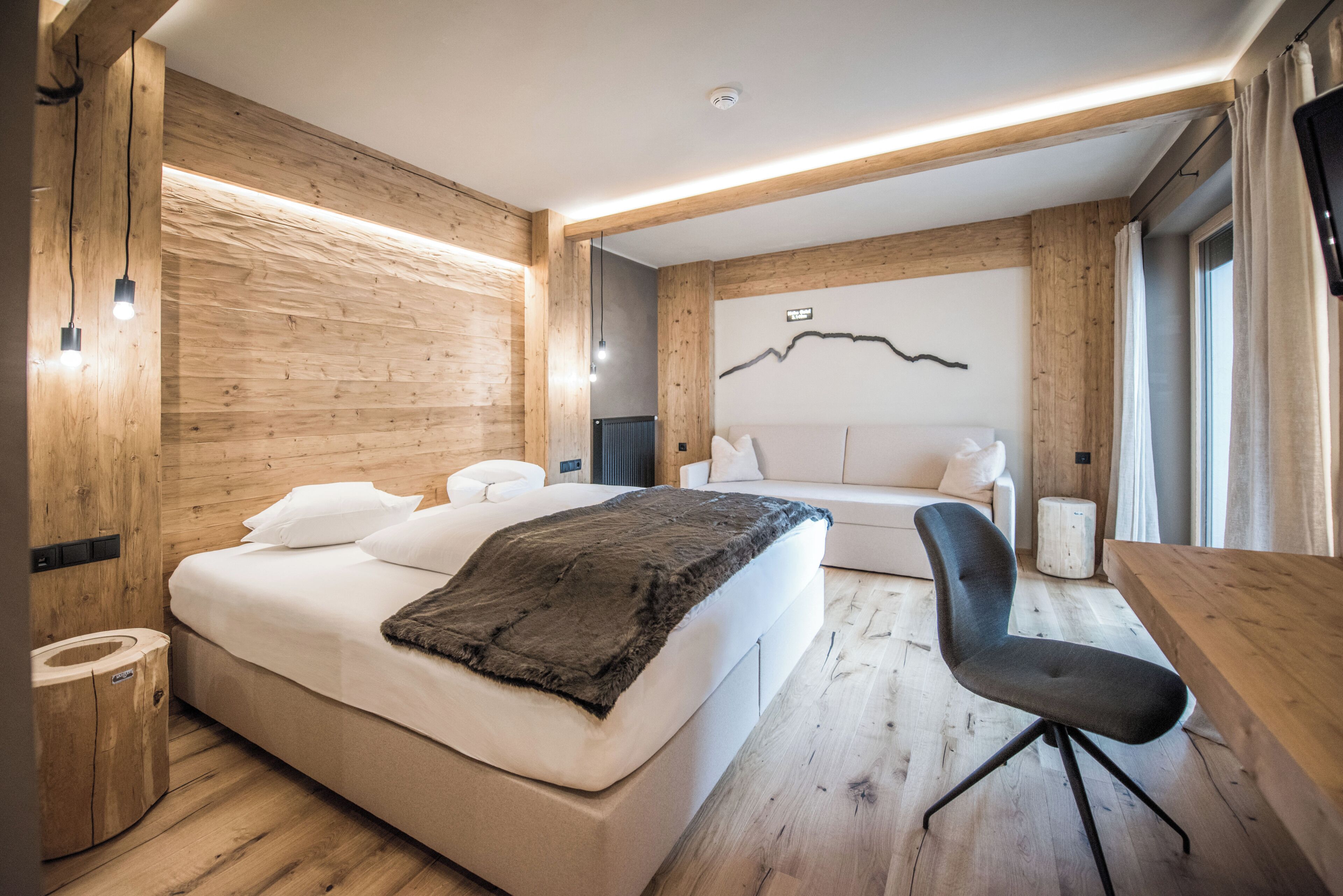 Ein modernes Schlafzimmer mit einem großen Bett, einem Schreibtisch und einem Sessel.