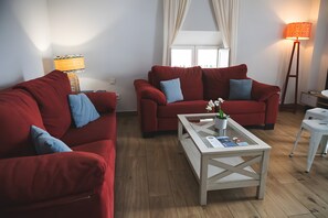 A living room with two red sofas, a white coffee table, and a floor lamp. - Spacious, Well-Equipped Superior Apartment (El Puerto de Santa María)