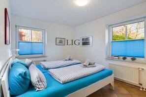 Ein Zimmer mit zwei Betten, einer Heizung und einem Fenster mit Jalousien.