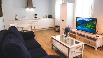 Una sala de estar moderna con un sofá, una mesa de centro y un televisor.