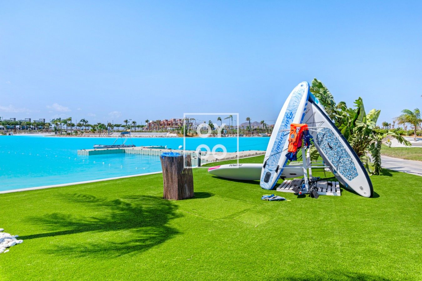 Un espace piscine avec une planche de surf et un fauteuil de relaxation.