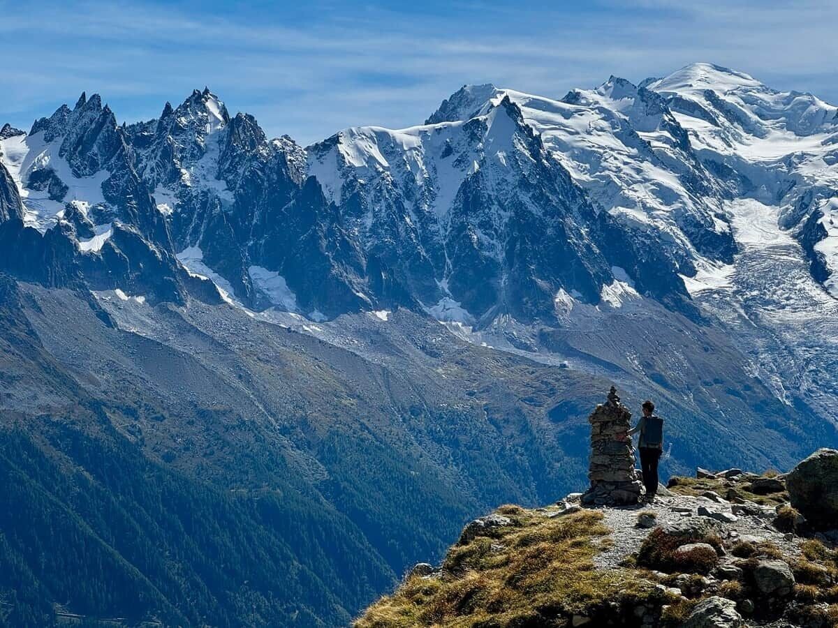 Eine gebirgige Landschaft mit einer Person auf einem Felsen.