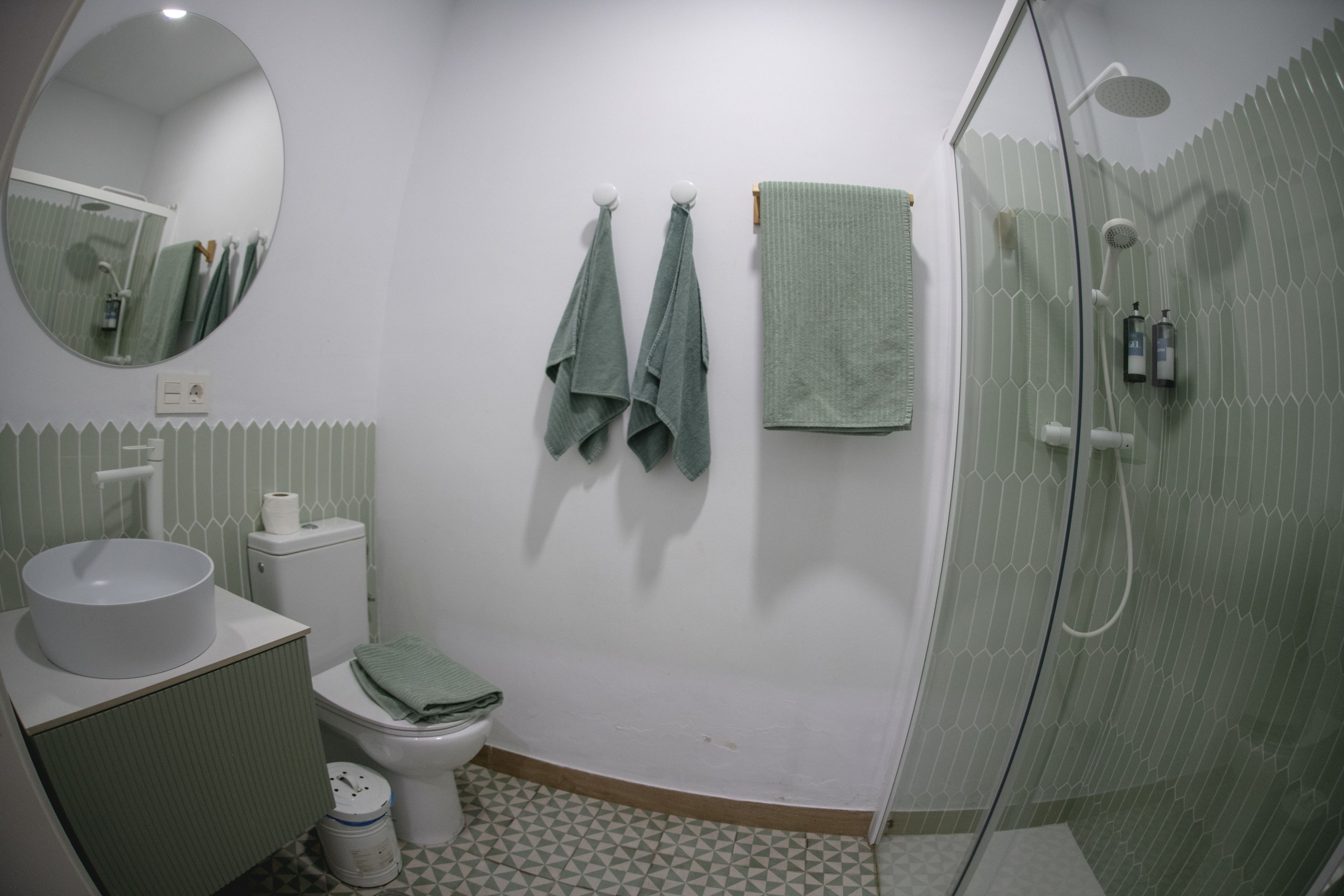 Een badkamer met toilet, wastafel en douche.