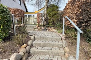 A stone staircase leading to a building with a white and yellow exterior. - Holiday home with 1 bedroom (Travemünde)