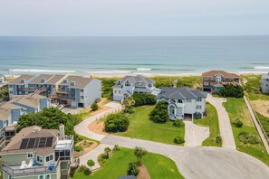 A coastal residential area with houses, a beach, and a clear view of the ocean. - Elevator, Theater Room, Game Room, Duck, Oceanfront, Pool, D0128 (Duck)