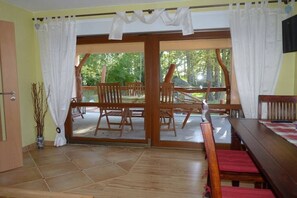 A room with a sliding glass door leading to an outdoor patio with wooden furniture. - Holiday home with 2 bedrooms (Heidesee OT Bindow)
