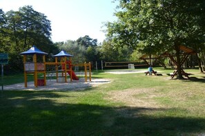 A playground with a slide, swings, and picnic tables. - Holiday home with 2 bedrooms (Heidesee OT Bindow)